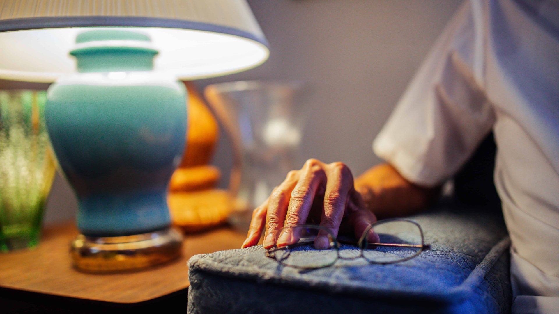 KHRC-7531 Elderly man's hand rests on the arm of his couch, next to glasses