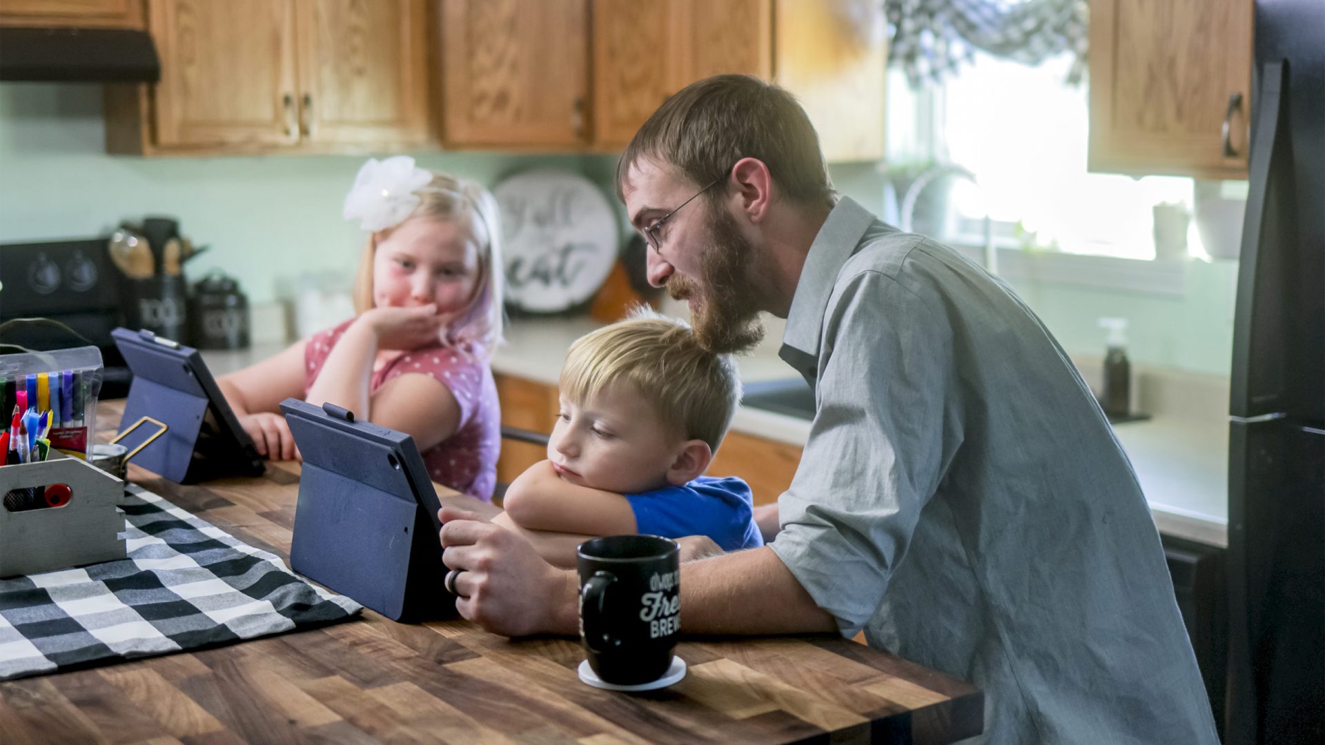 KHRC-Topeka-06 Father helping two children with tablets at kitchen island